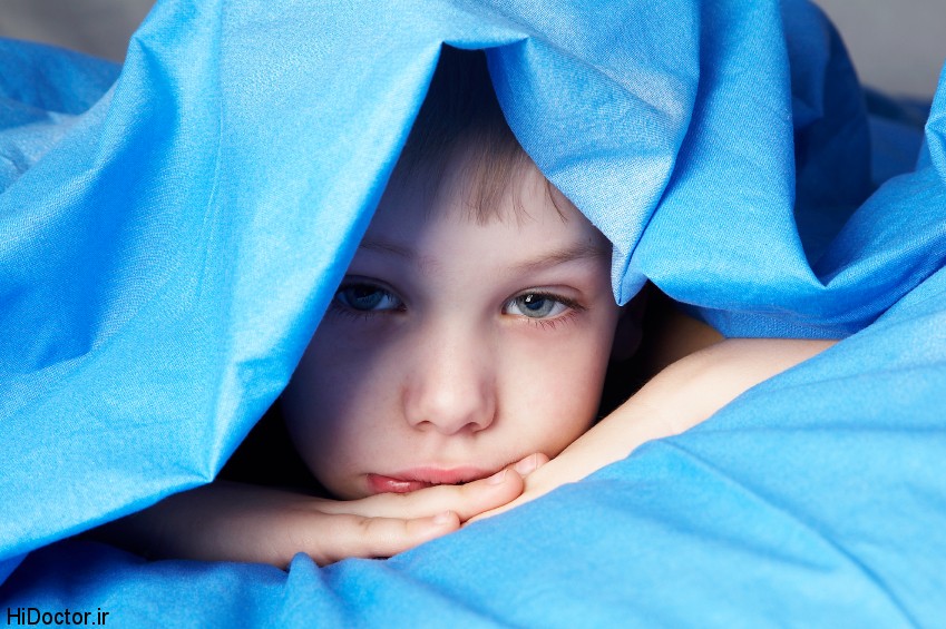 sleepy boy in blue bedclothes