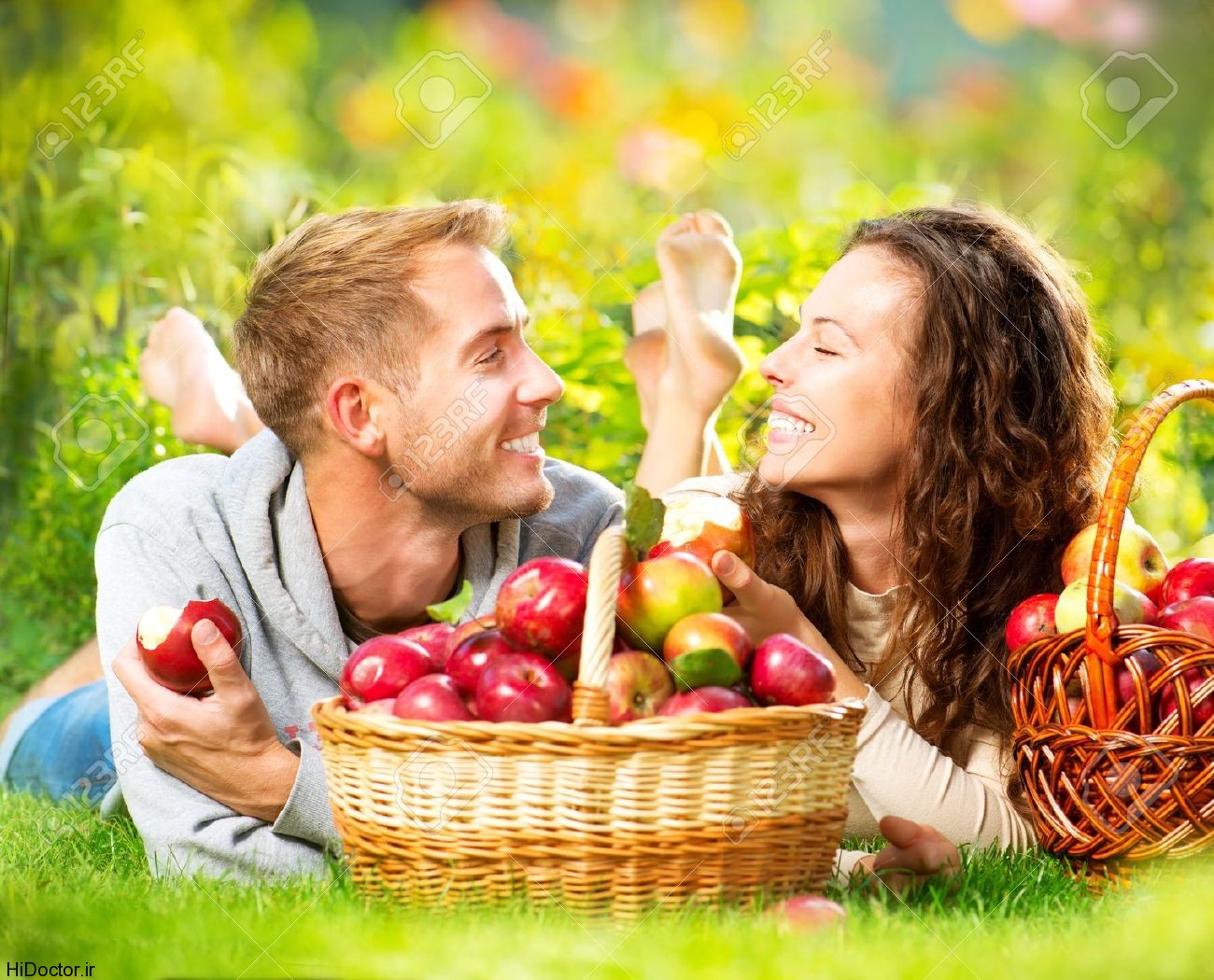15512917-couple-relaxing-on-the-grass-and-eating-apples-in-autumn-garden