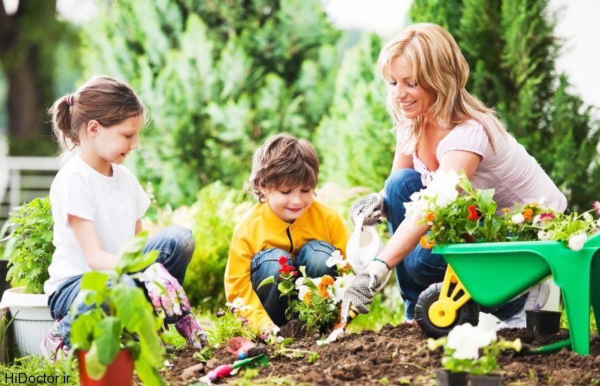 Mother, daughter and son planting flowers together.