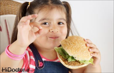 kid eating burger for constipation کاهش میل کودکان از خوردن غذاهای آماده