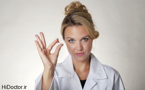 woman-in-lab-coat-holding-pill