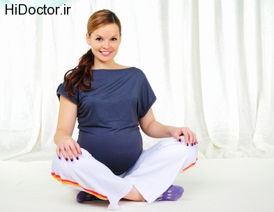 Portrait of a young pregnant girl on a light background doing exercises