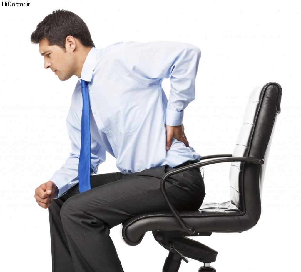 Young businessman with backache sitting in an office chair. Horizontal shot. Isolated on white.