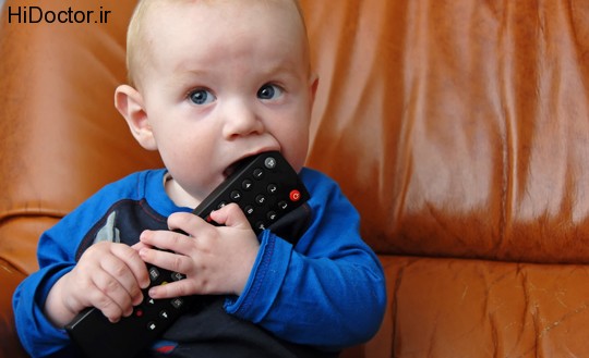 Baby boy chewing a tv remote