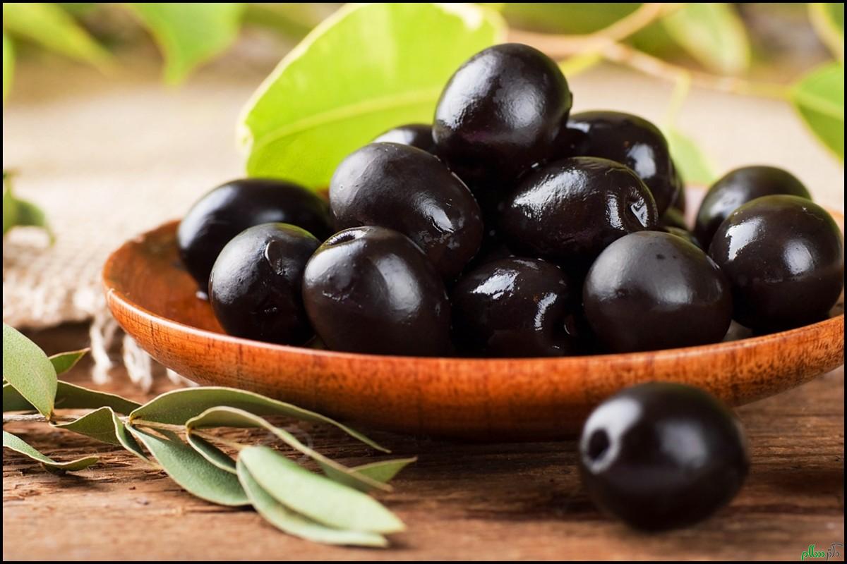 Black-olives-close-up-on-wooden-plate