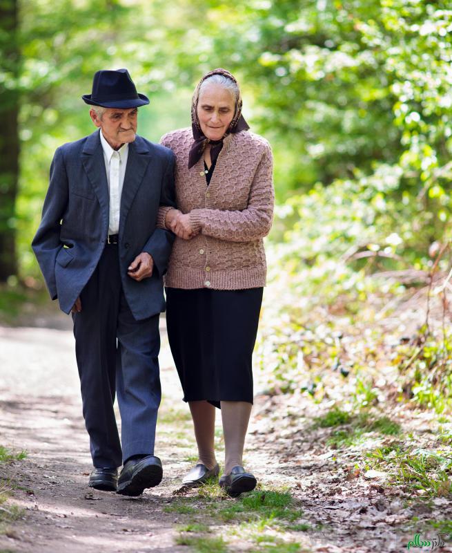 elderly-man-and-woman-walking-along-path
