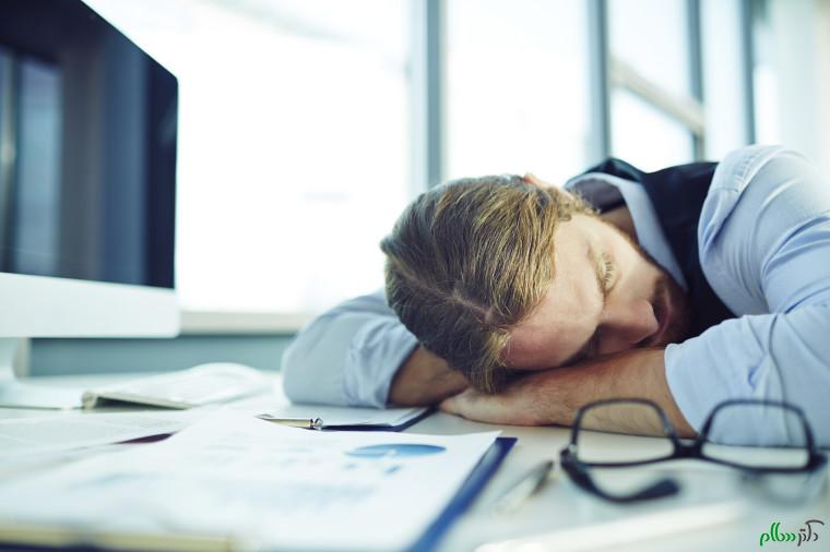 Young businessman sleeping by his desk in office