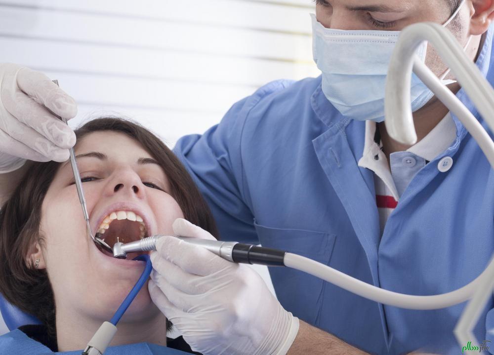 male-dentist-in-blue-working-on-womans-teeth