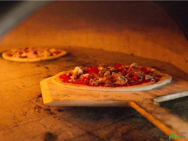 montreal-que-may-08-2015-pizza-slides-into-wood-oven