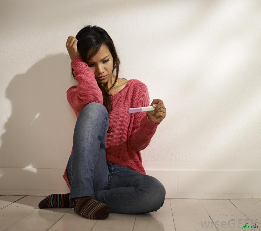 sad-woman-in-pink-sweater-and-jeans-looking-at-pregnancy-test