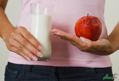 getty_rf_photo_of_woman_holding_apple_and_milk