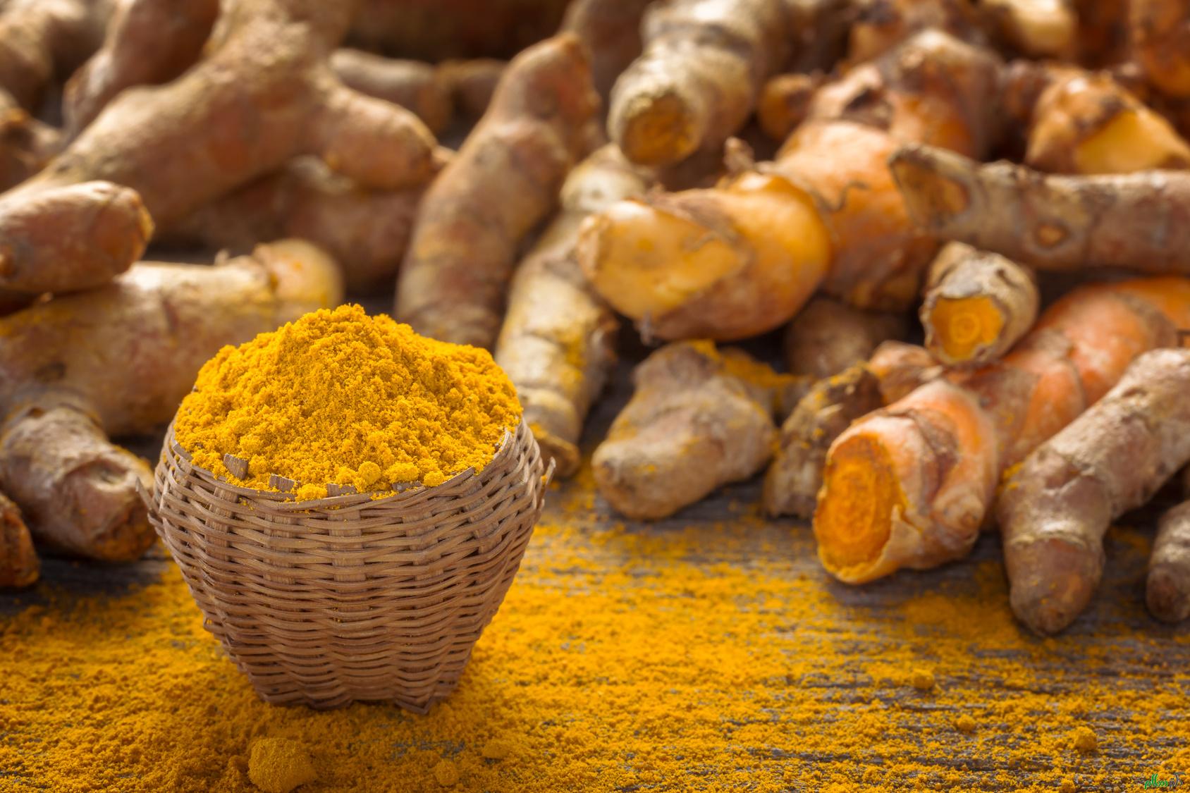 Close up turmeric powder on grunge wooden background.