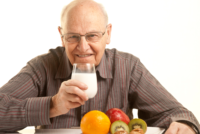 Senior man having a healthy breakfast isolated on white
