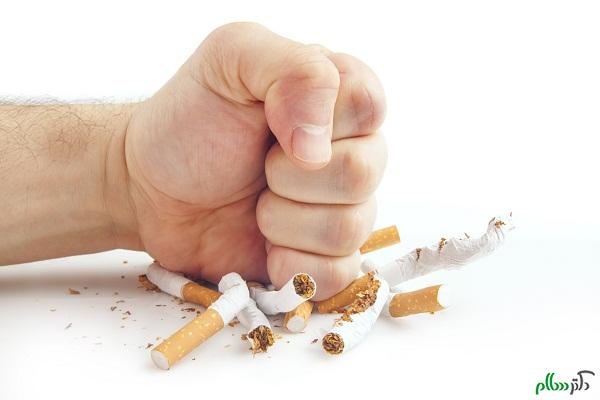 Human fist breaking cigarettes on white background